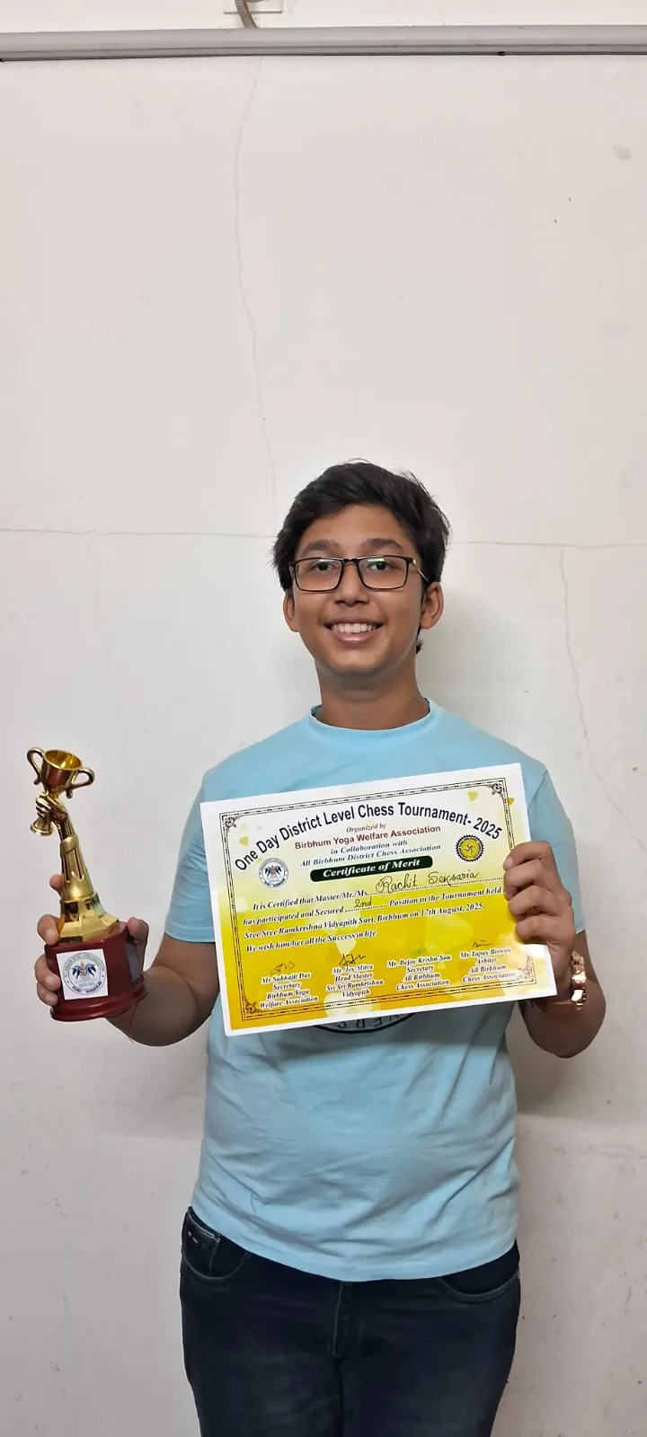 Rachit holding a trophy and certificate at District Level Chess Tournament 2025